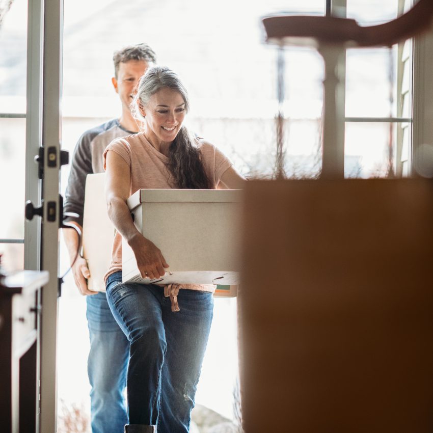 Mature Couple with Moving Boxes in New Home A couple in their 50's moves in to their new home, unpacking boxes and enjoying the time together. Could also depict moving out of a home.